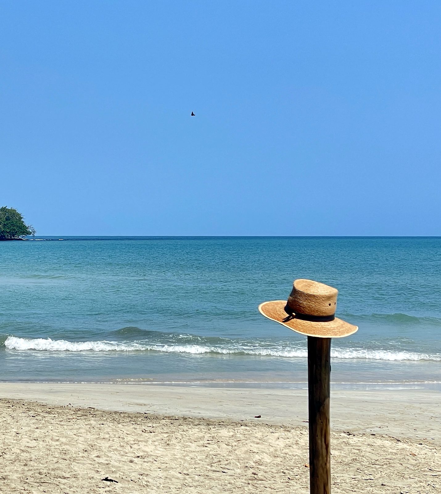 A straw hat on a post at a calm beach on the Caribbean side of Costa Rica