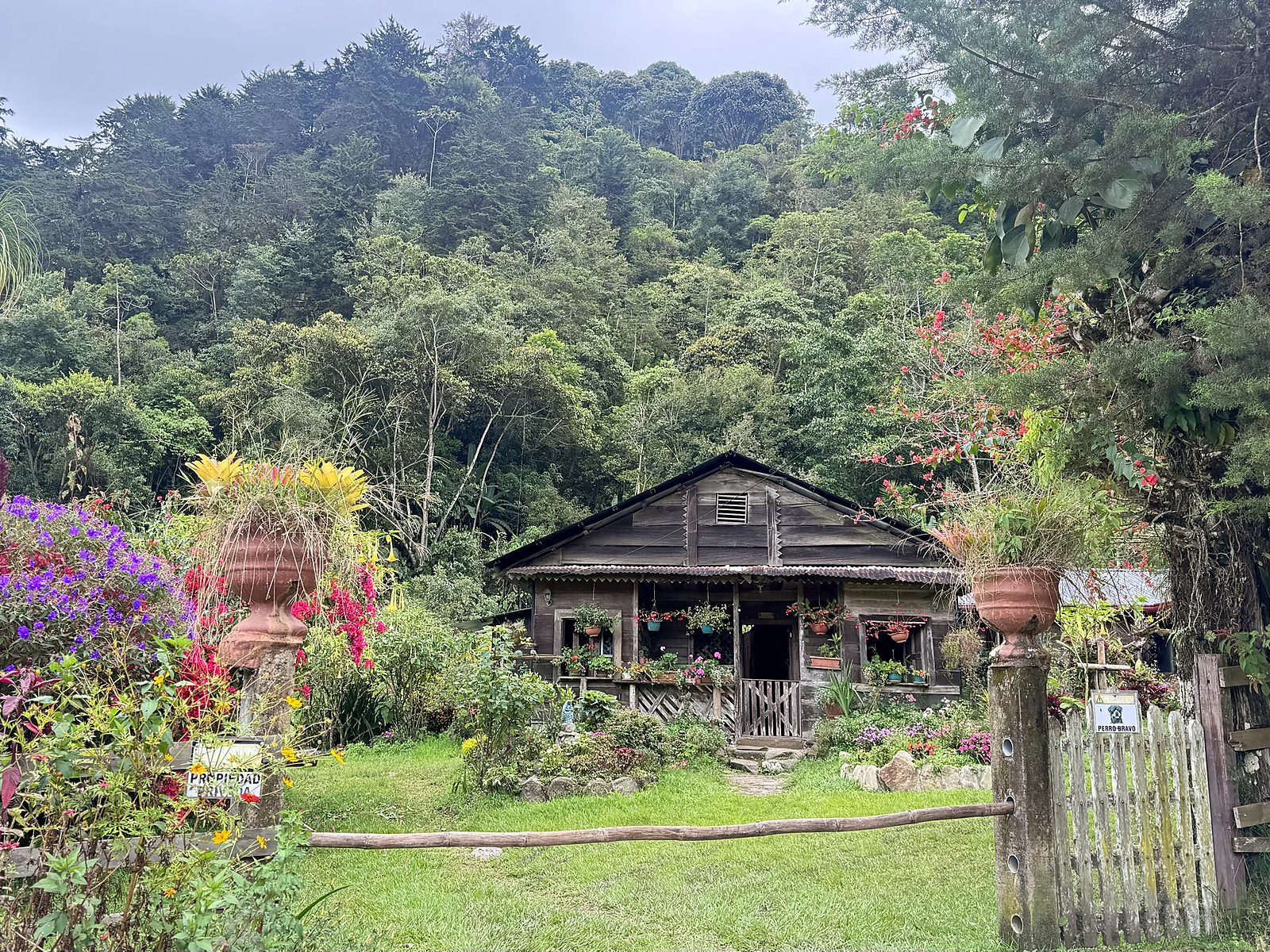 A wooden lodging house with a flower garden at the entrance to Chirripó National Park