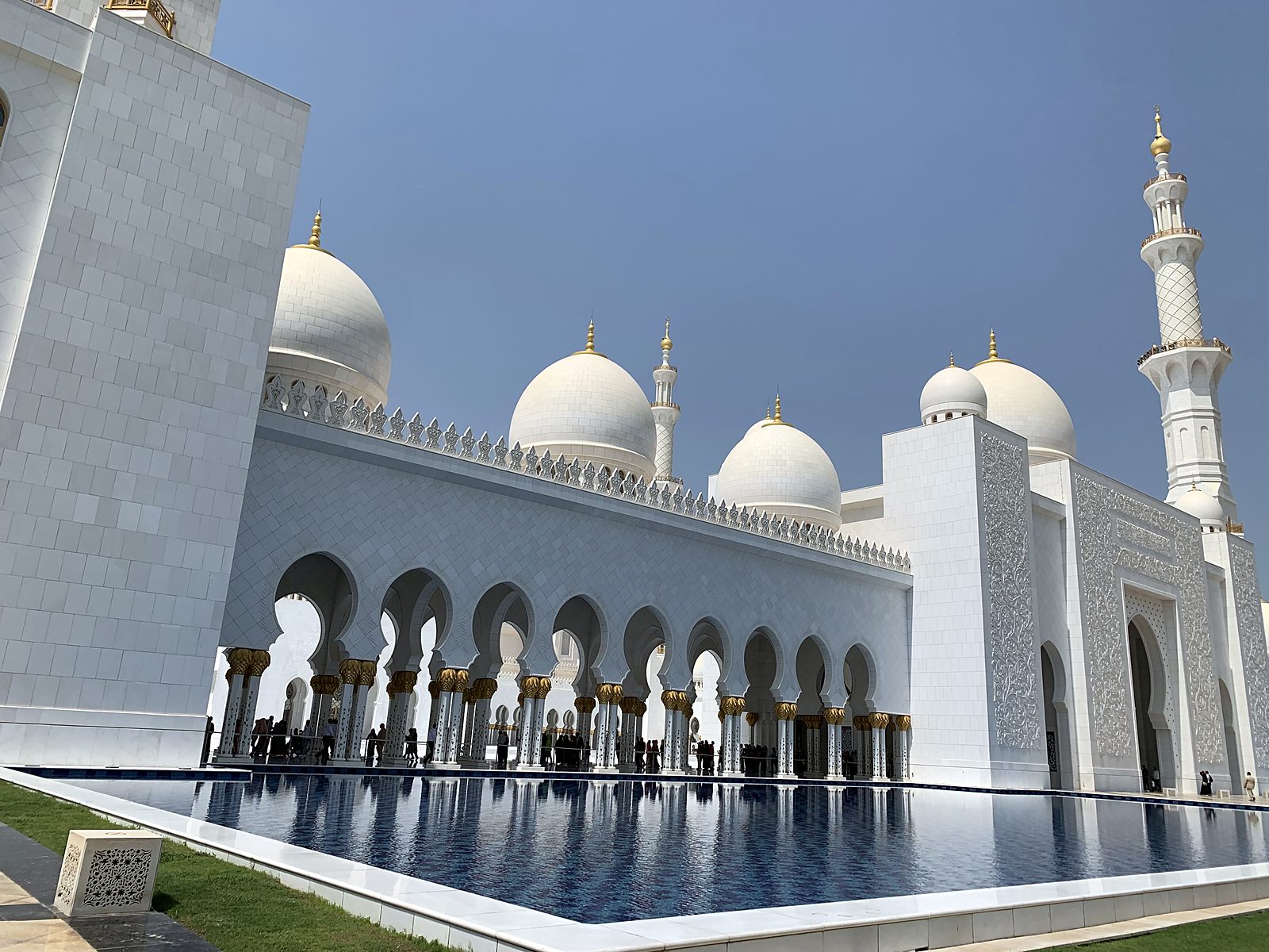 The Sheikh Zayed Grand Mosque in Abu Dhabi, with white domes and a reflecting pool