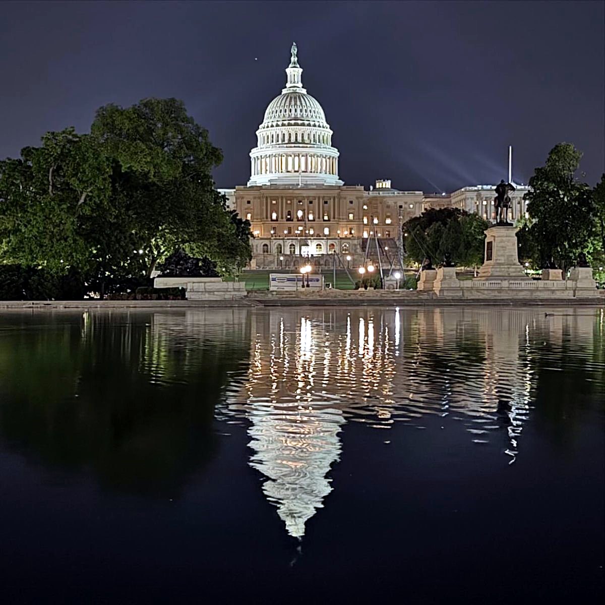 The U.S. Capitol at night, reflected in the water