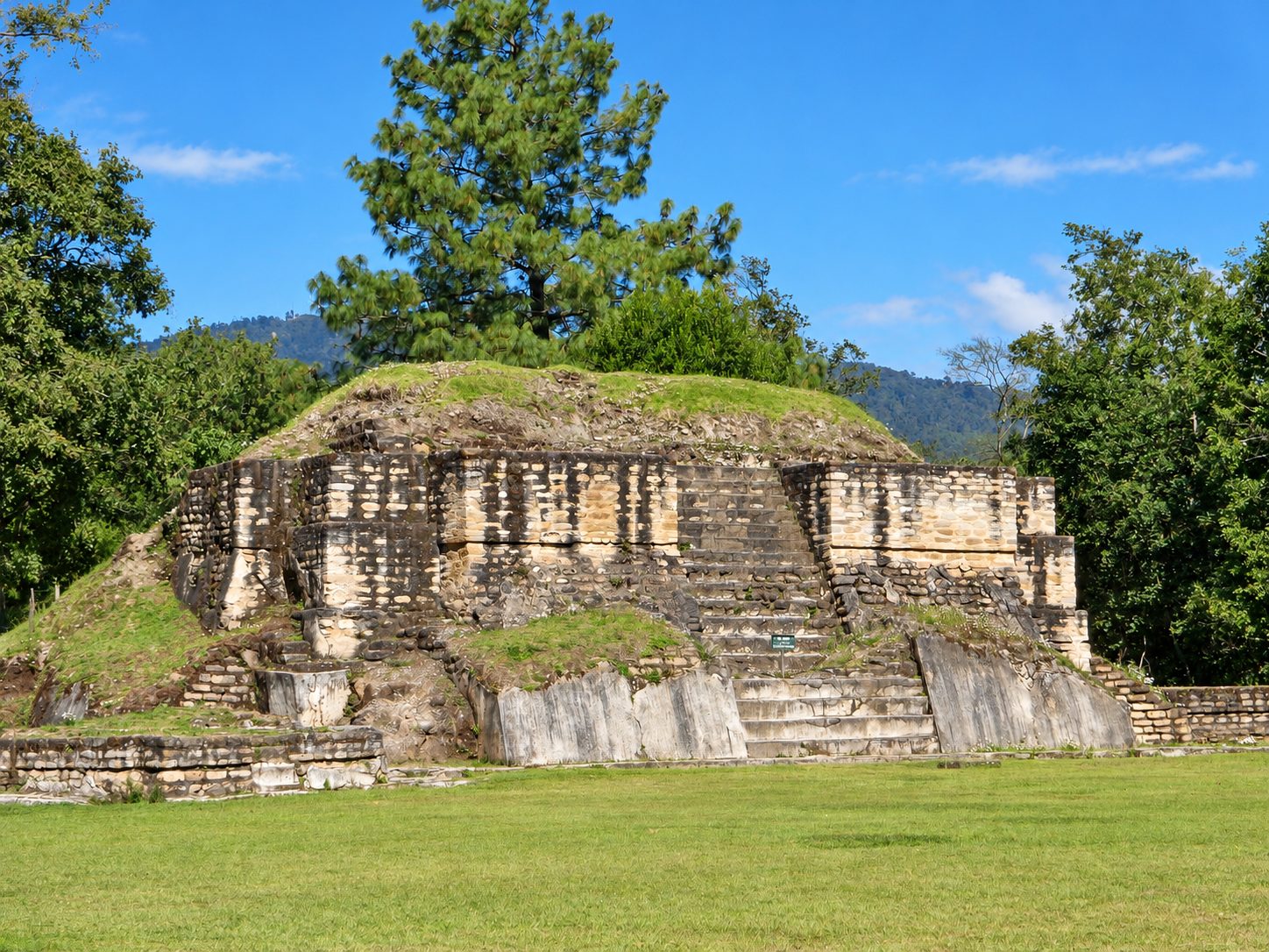 Old Mayan stone ruins on green grass in Guatemala