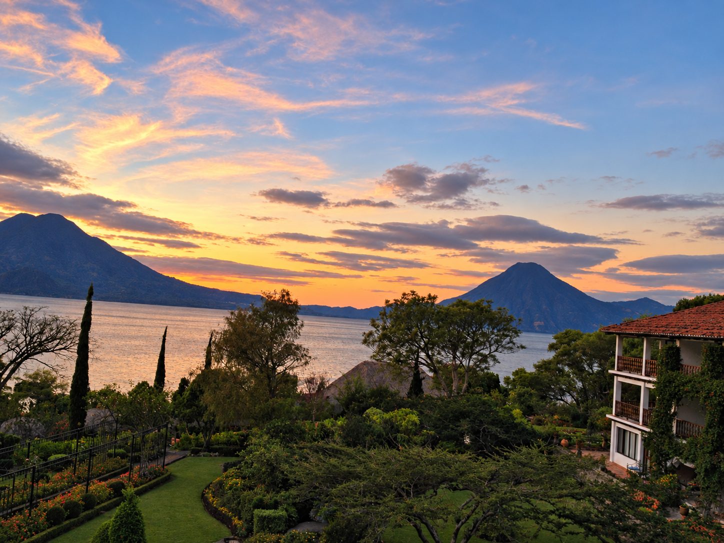 Lake Atitlán at sunset with gardens and volcanoes