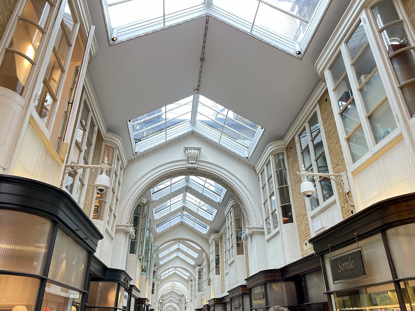 A covered shopping arcade with a glass roof in London