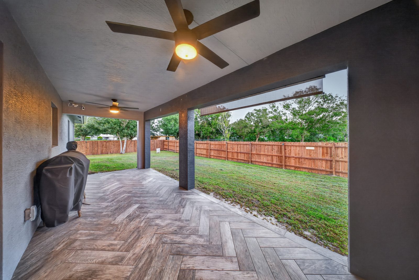 Covered back patio looking out to the fenced yard