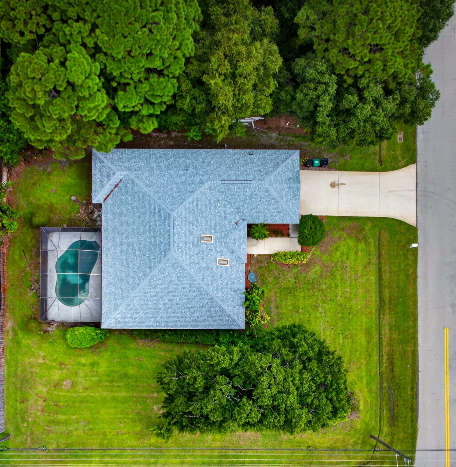 Aerial view of the home and the pool on a corner lot